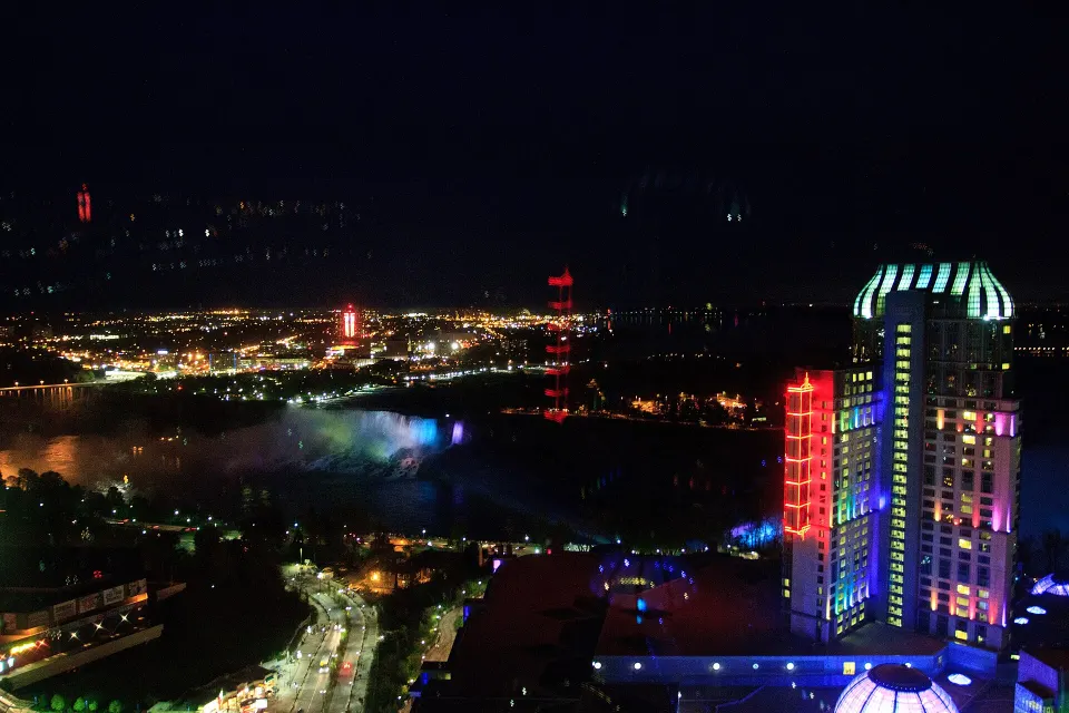 Fallsview Casino Resort tower above the illuminated Niagara Falls at night